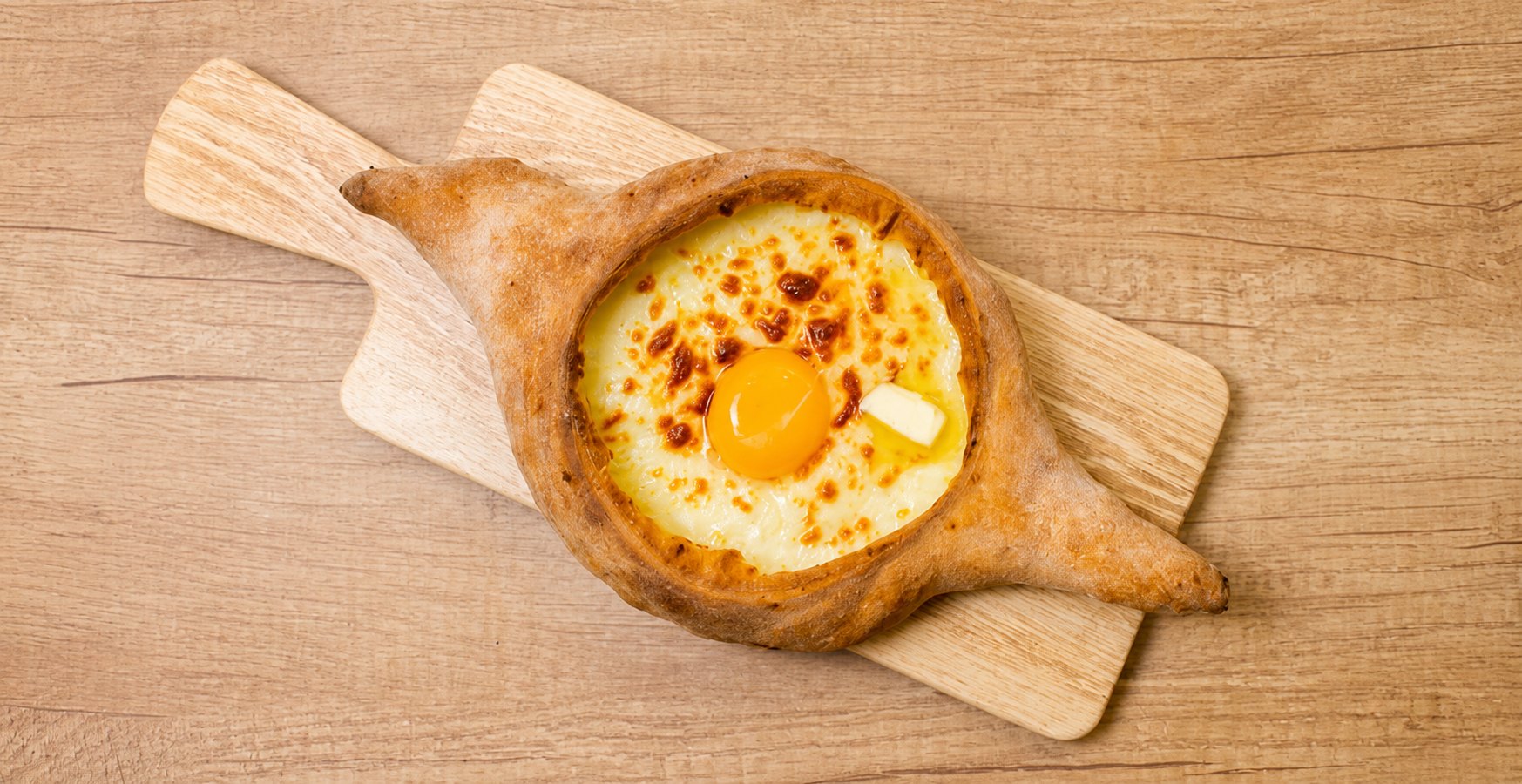 Adjaruli khachapuri — cheese boat with egg yolk and butter