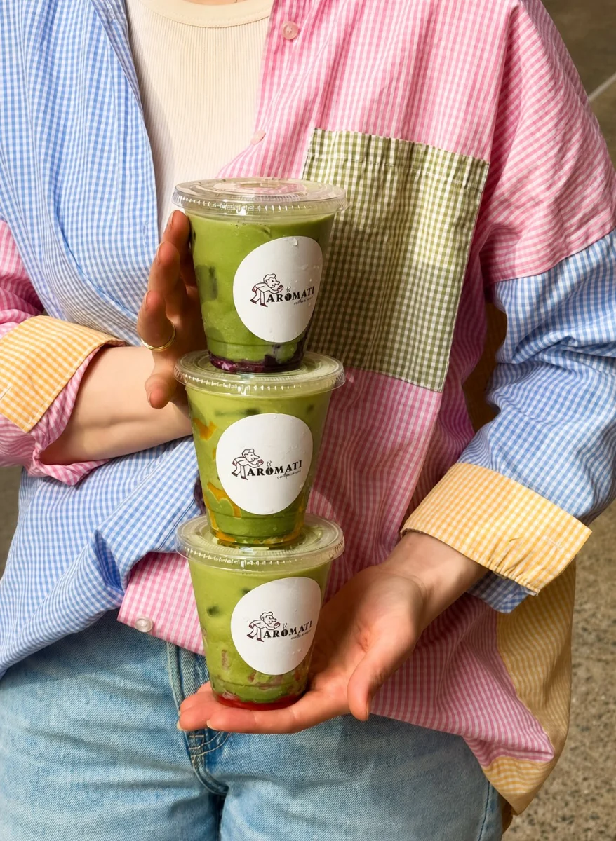 Three fruit matcha lattes held in a stack
